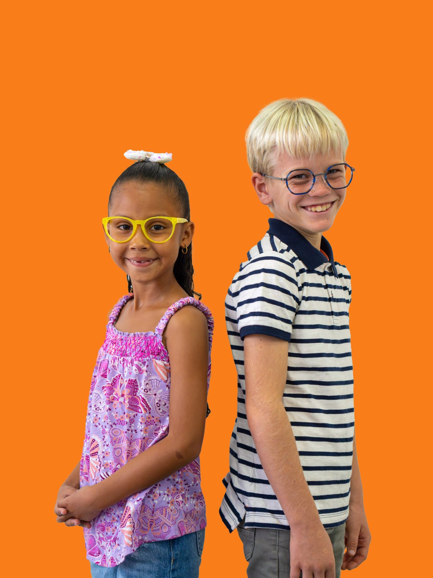 Two smiling children wearing colorful glasses