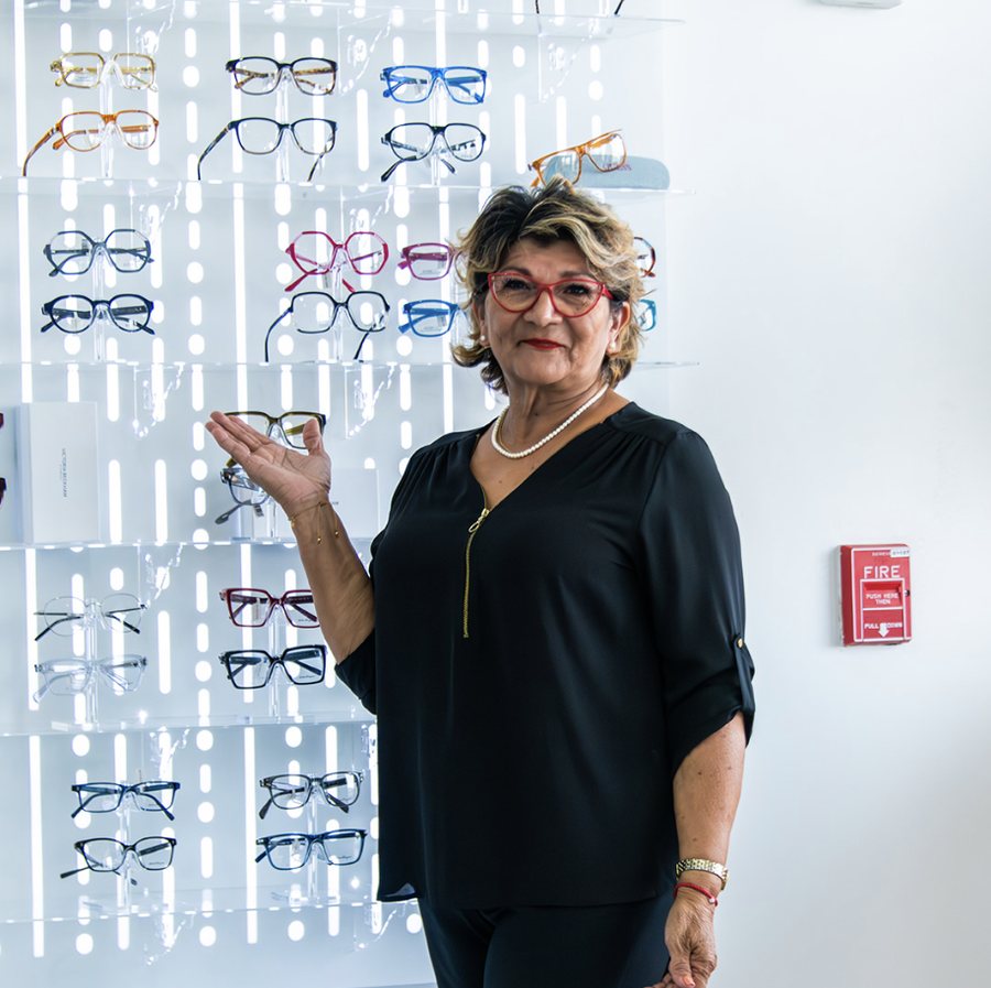 Optician presenting a wall of frames